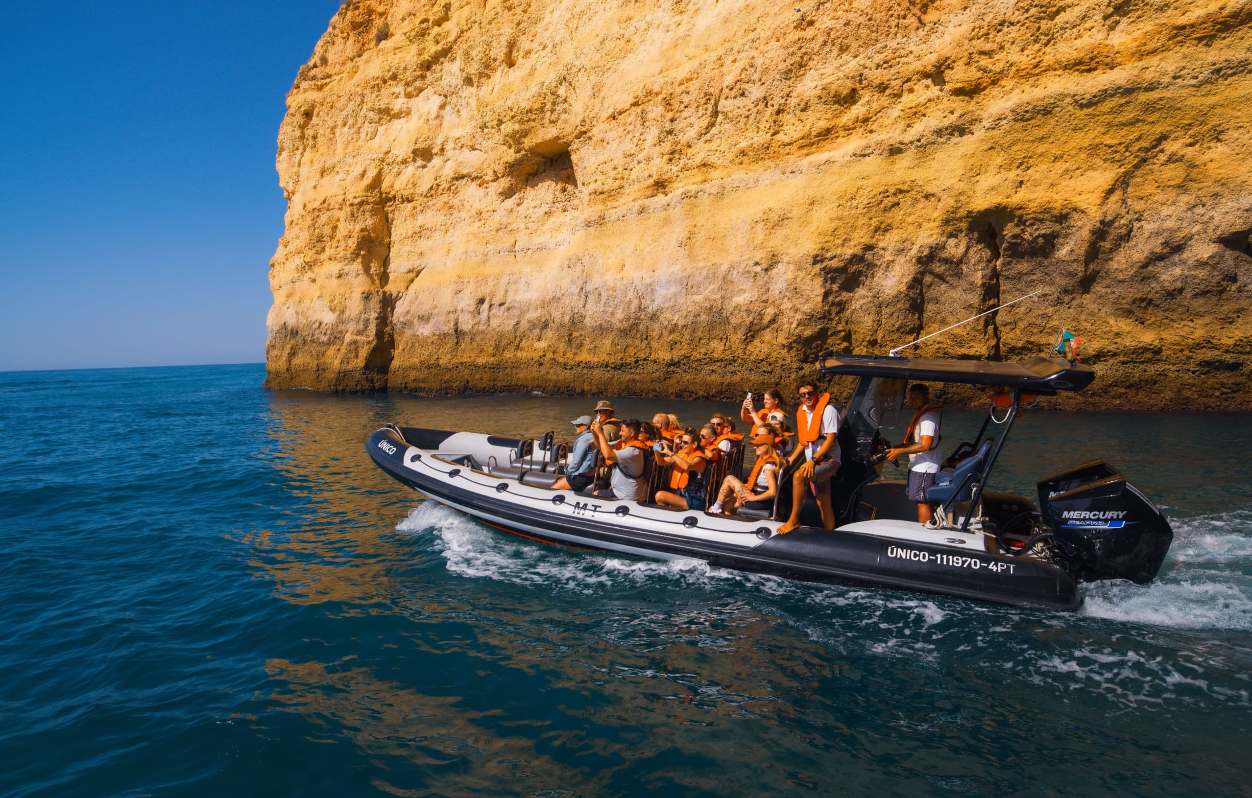 Tourists exploring the Algarve coastline on a speedboat adventure