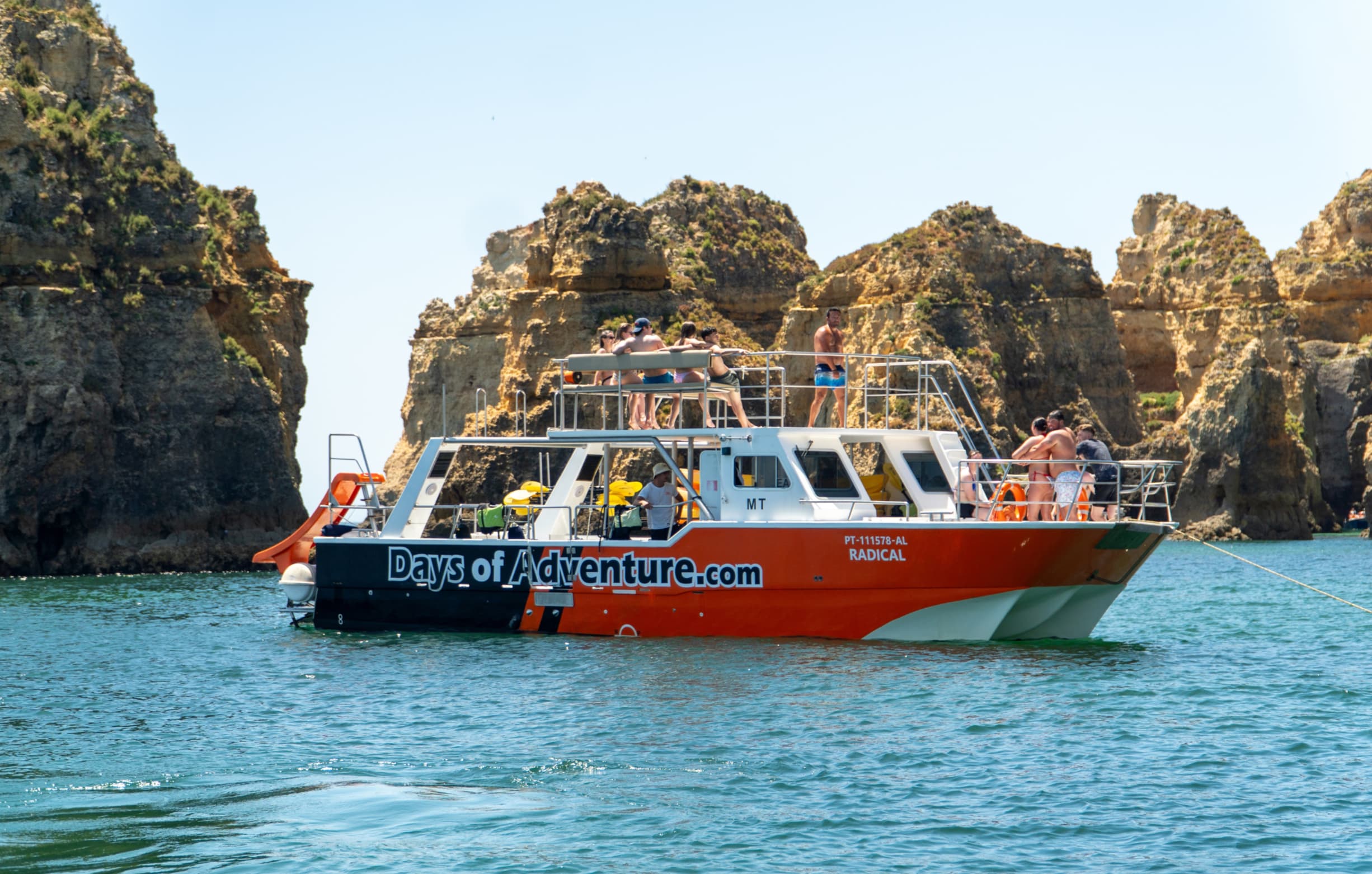 Tourists kayaking through the rock formations of Algarve