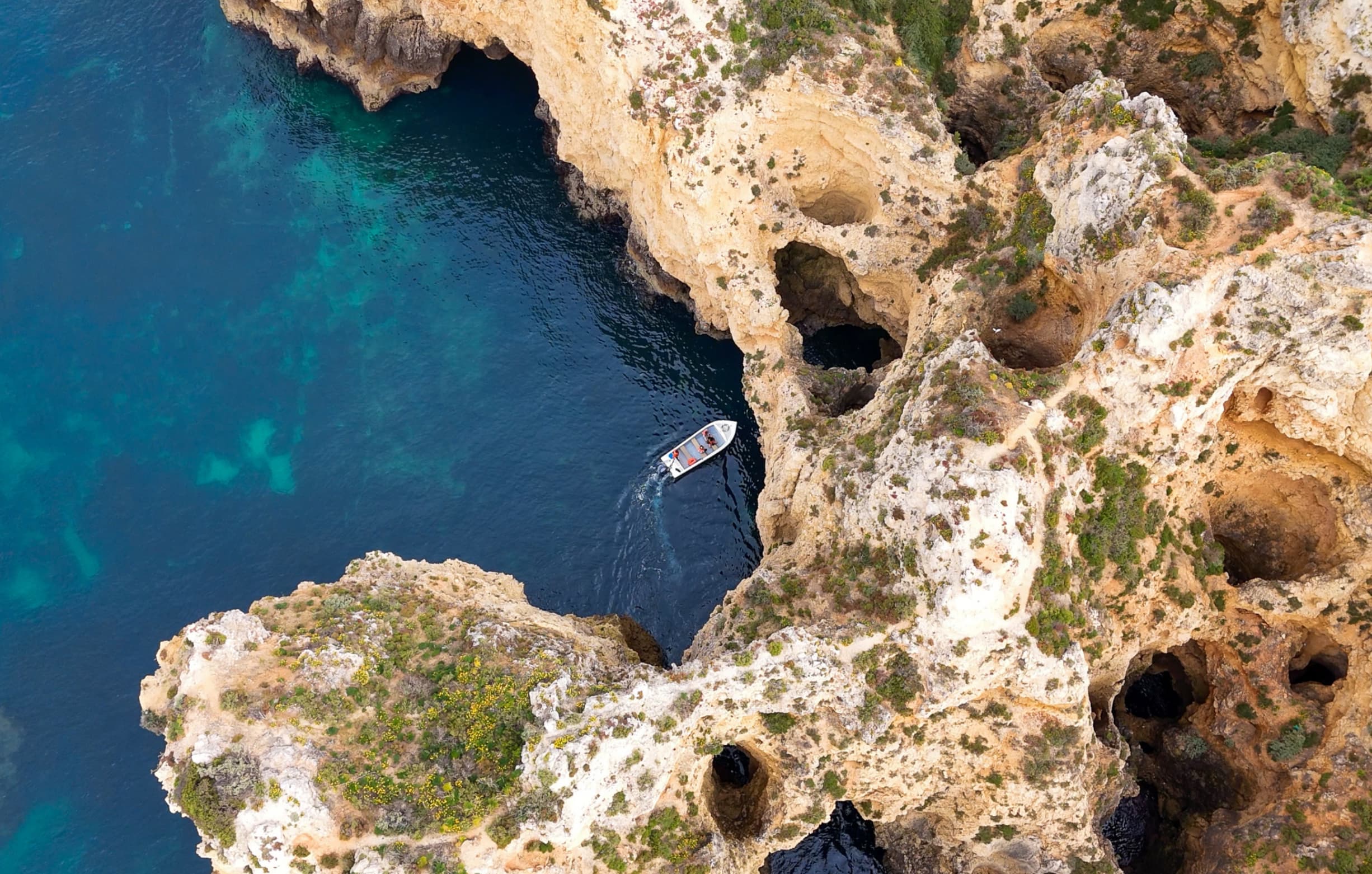 Boat navigating through the caves of Ponta da Piedade