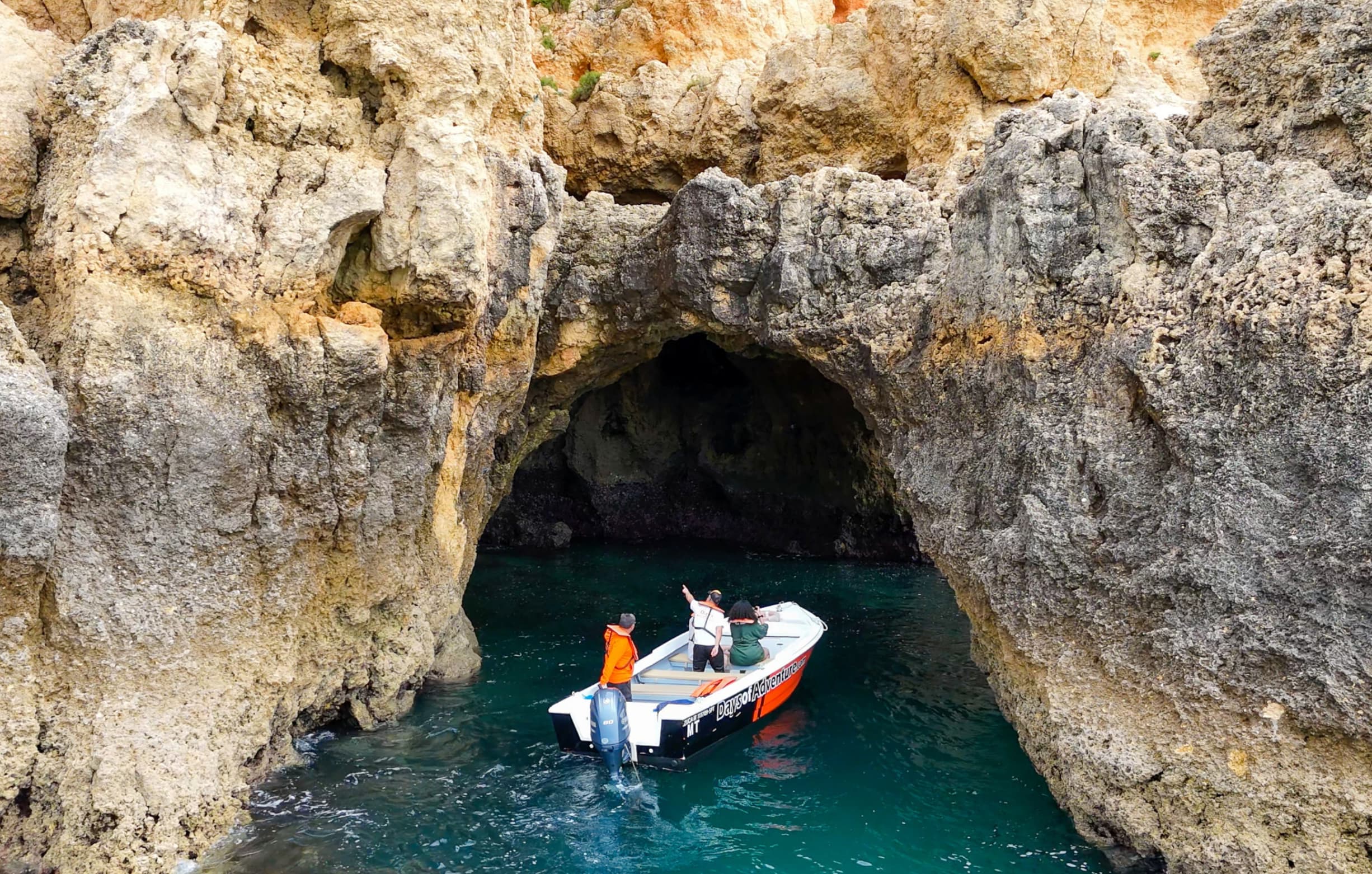 Passengers enjoying a cave boat tour along the Algarve coast