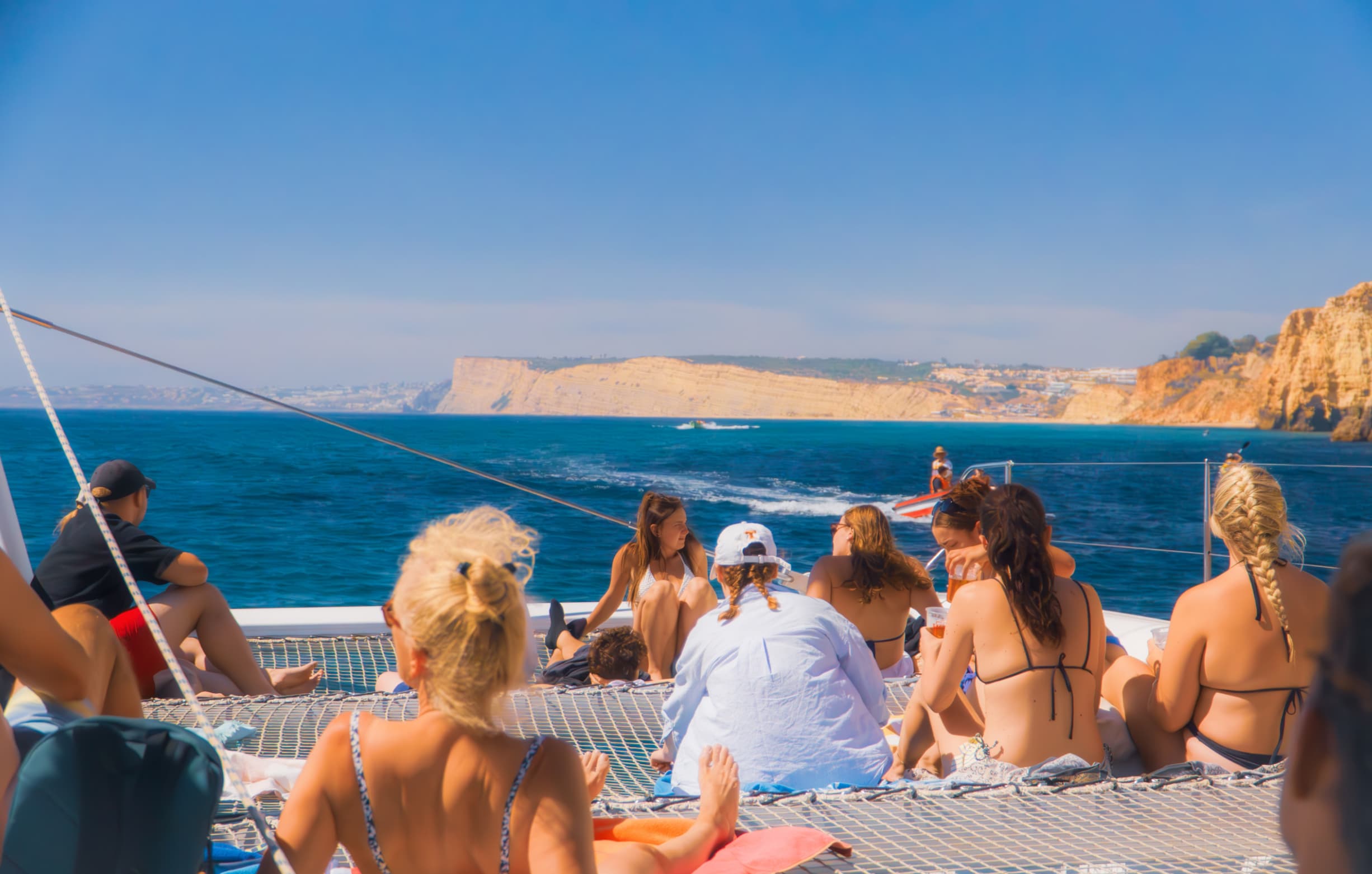 Luxury sailing catamaran cruising near the Algarve cliffs